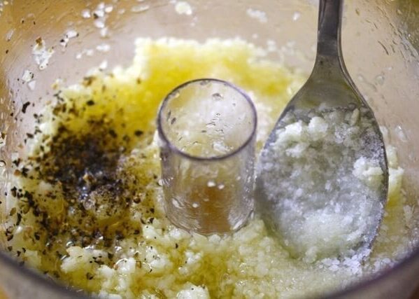 Garlic with salt, pepper, and oil in food processor