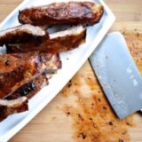 Plate of Chinese ribs on cutting board with cleaver