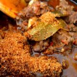 Adding coconut flakes to Indian lamb curry