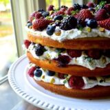 Three layer cake with whipped cream and fresh berries