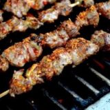 Beijing lamb skewers on grill with chili flakes
