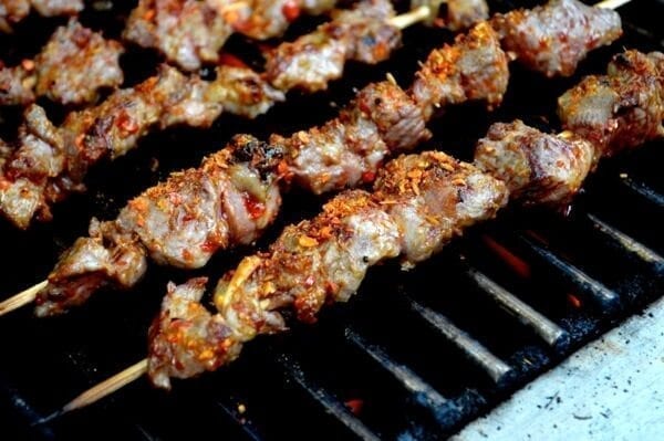 Beijing lamb skewers on grill with chili flakes