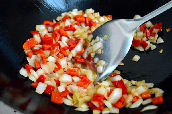 Sauteeing onions and peppers in wok