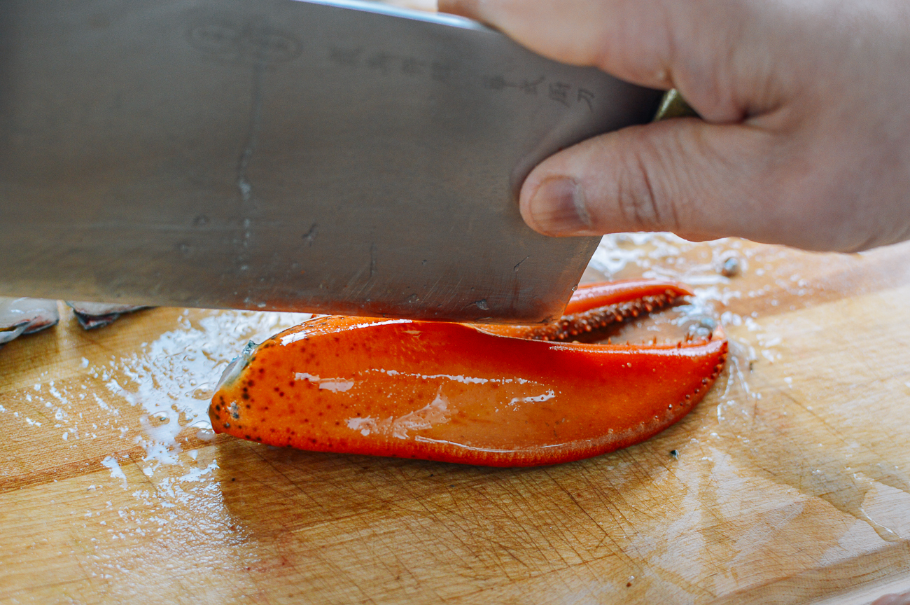 cutting lobster claw in half with cleaver