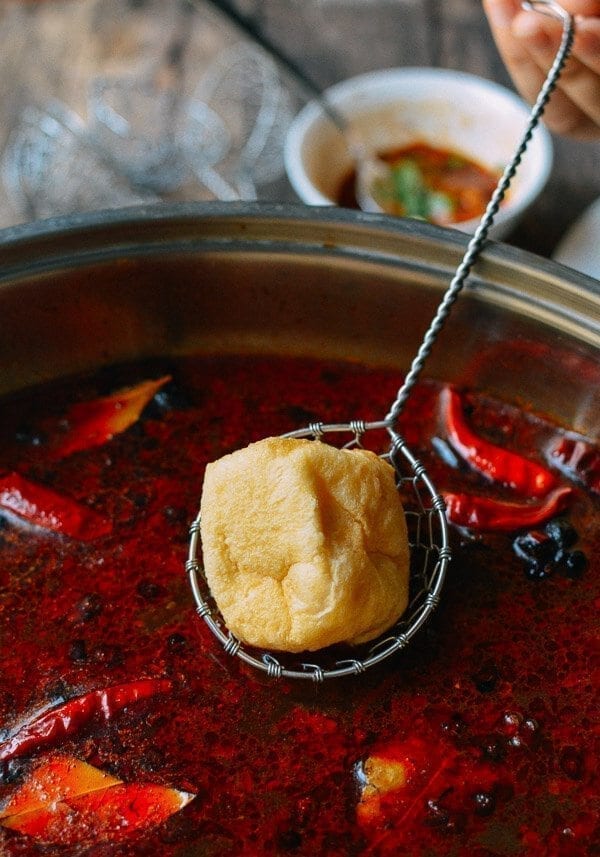 Dipping Soy Puff into Sichuan Hot Pot, by thewoksoflife.com