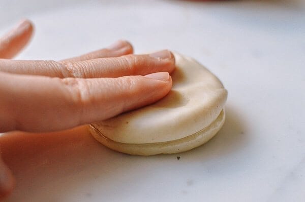 Pressing two discs of dough, by thewoksoflife.com