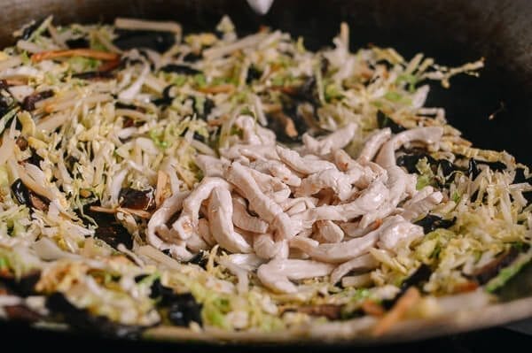 Adding pre-cooked chicken back to wok of vegetables, by thewoksoflife.com