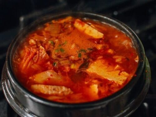 How do you make kimchi jjigae less spicy?