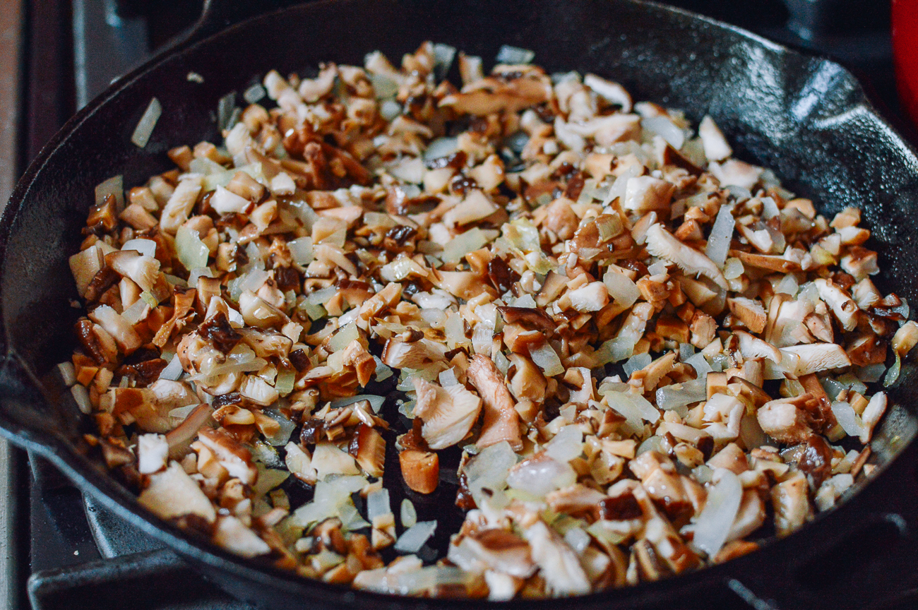 chopped onions and shiitake mushrooms in cast iron skillet
