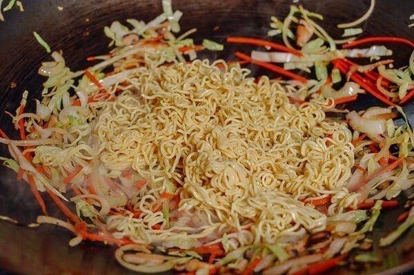 Adding yakisoba noodles to wok, by thewoksoflife.com