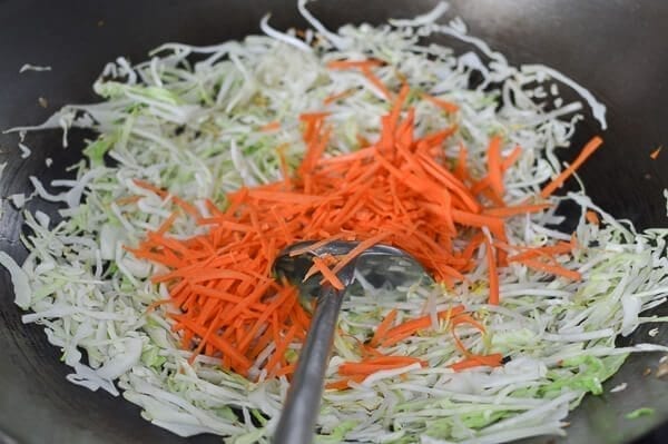 Add shredded cabbage and carrots, by thewoksoflife.com