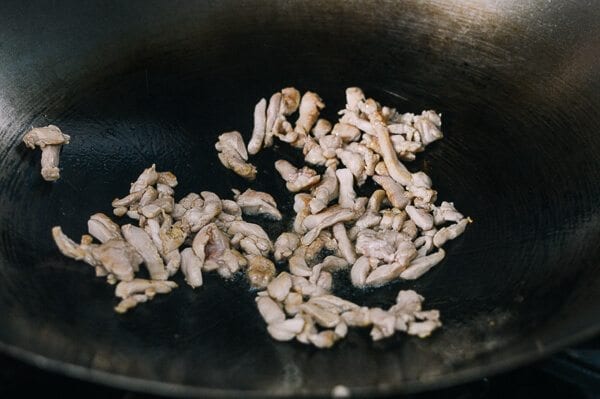 Searing strips of chicken in wok, by thewoksoflife.com