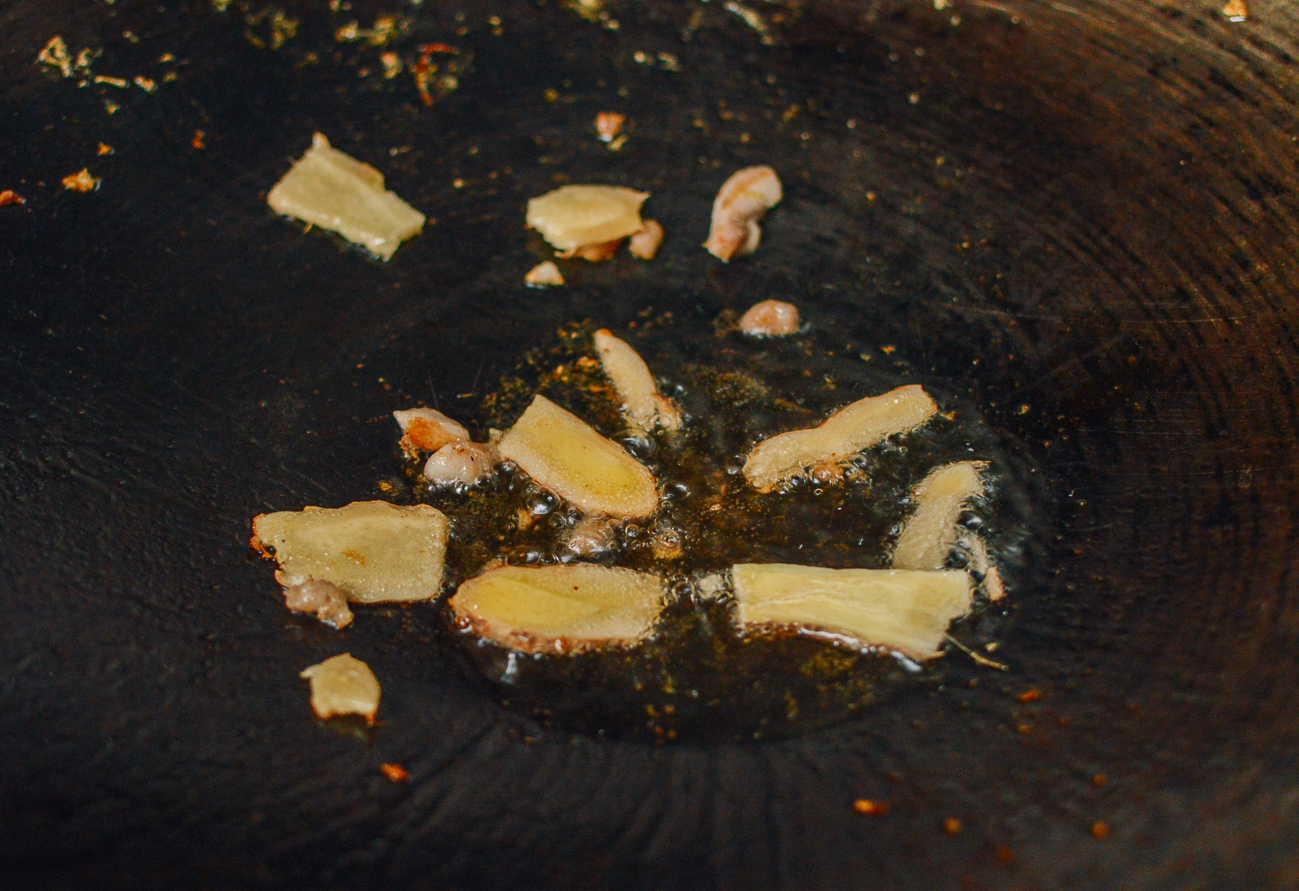 cooking slices of ginger in wok