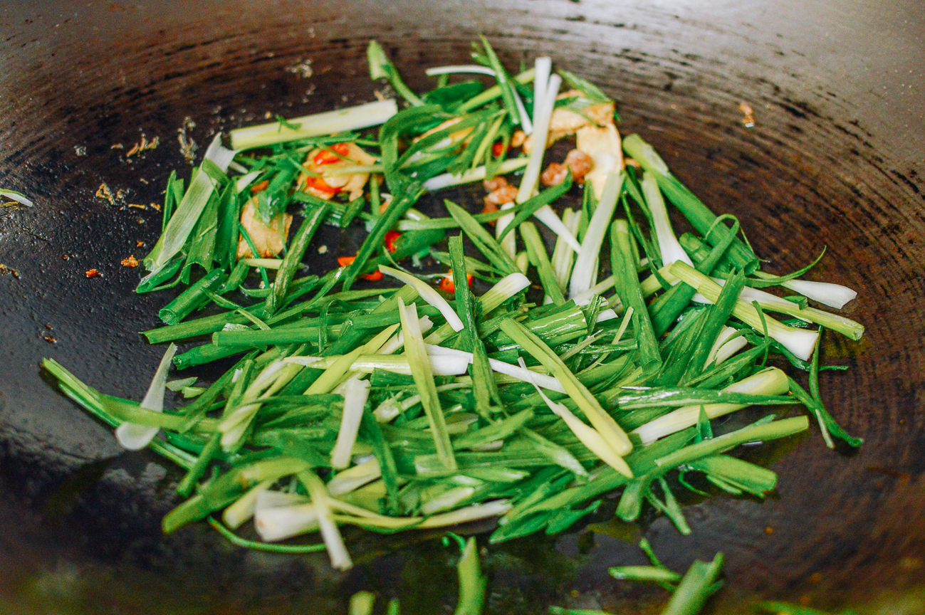scallions, red chili, and ginger in wok