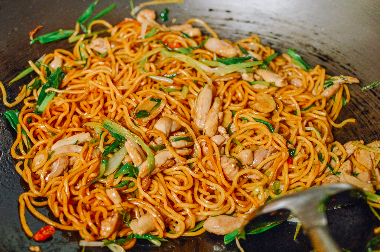 stir-frying hokkien noodles in wok