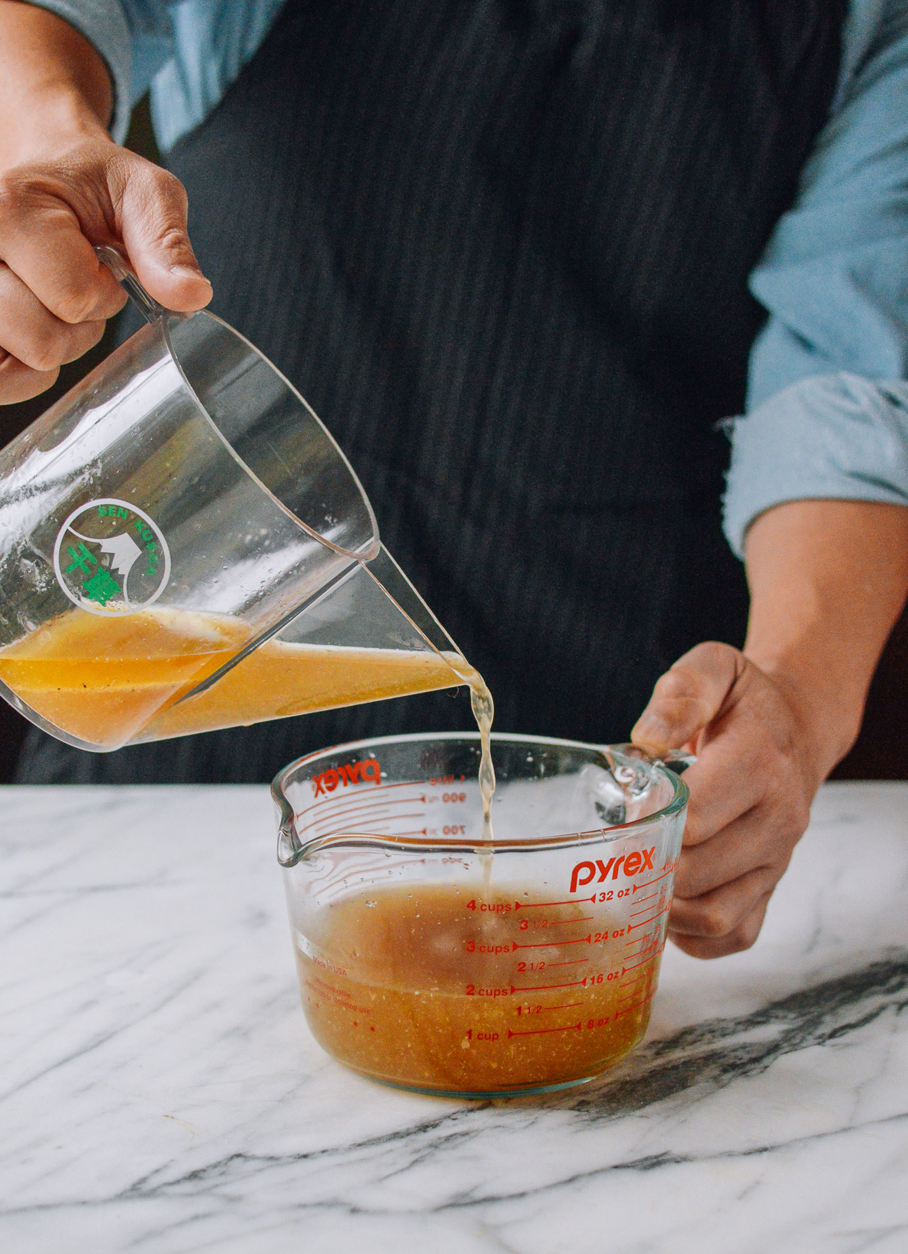 pouring turkey juices out of fat separator into measuring cup