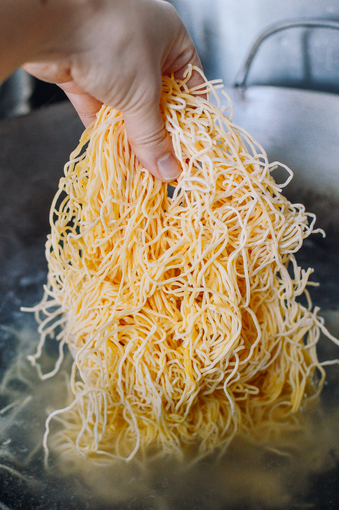 adding fresh hong kong style pan-fried noodles to boiling water