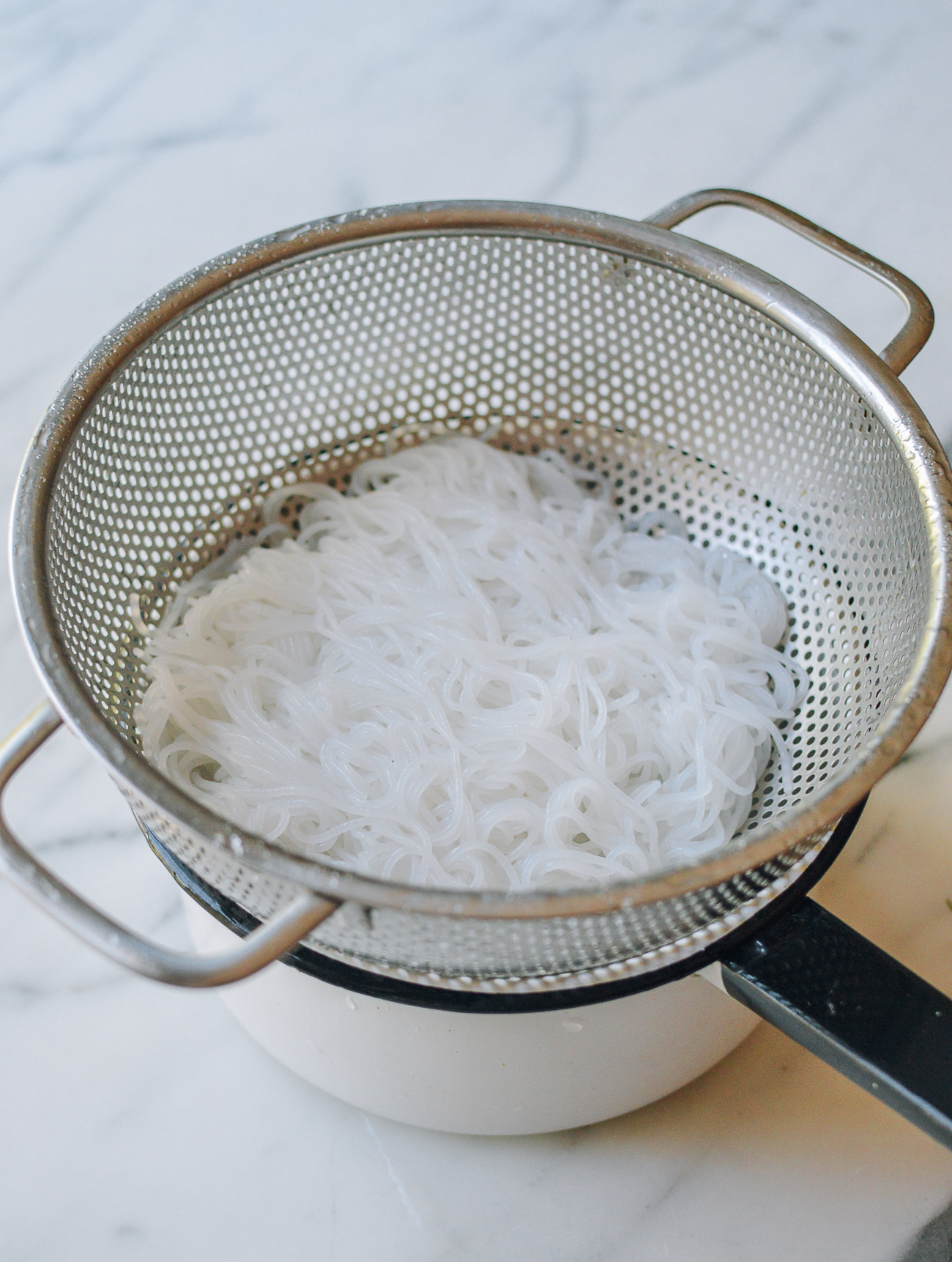 drained rice noodles in colander