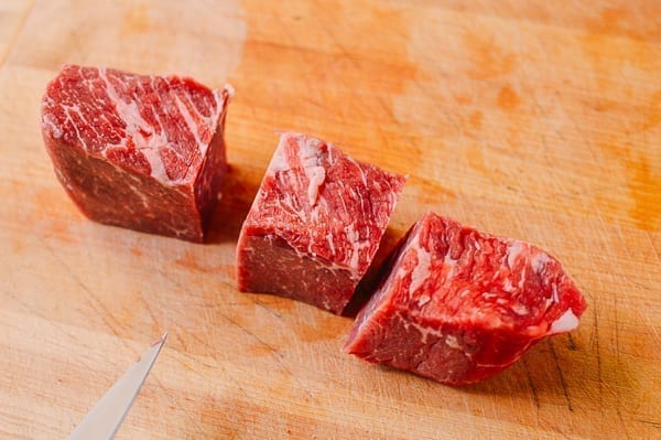 beef chuck steak pieces on a cutting board by thewoksoflife.com