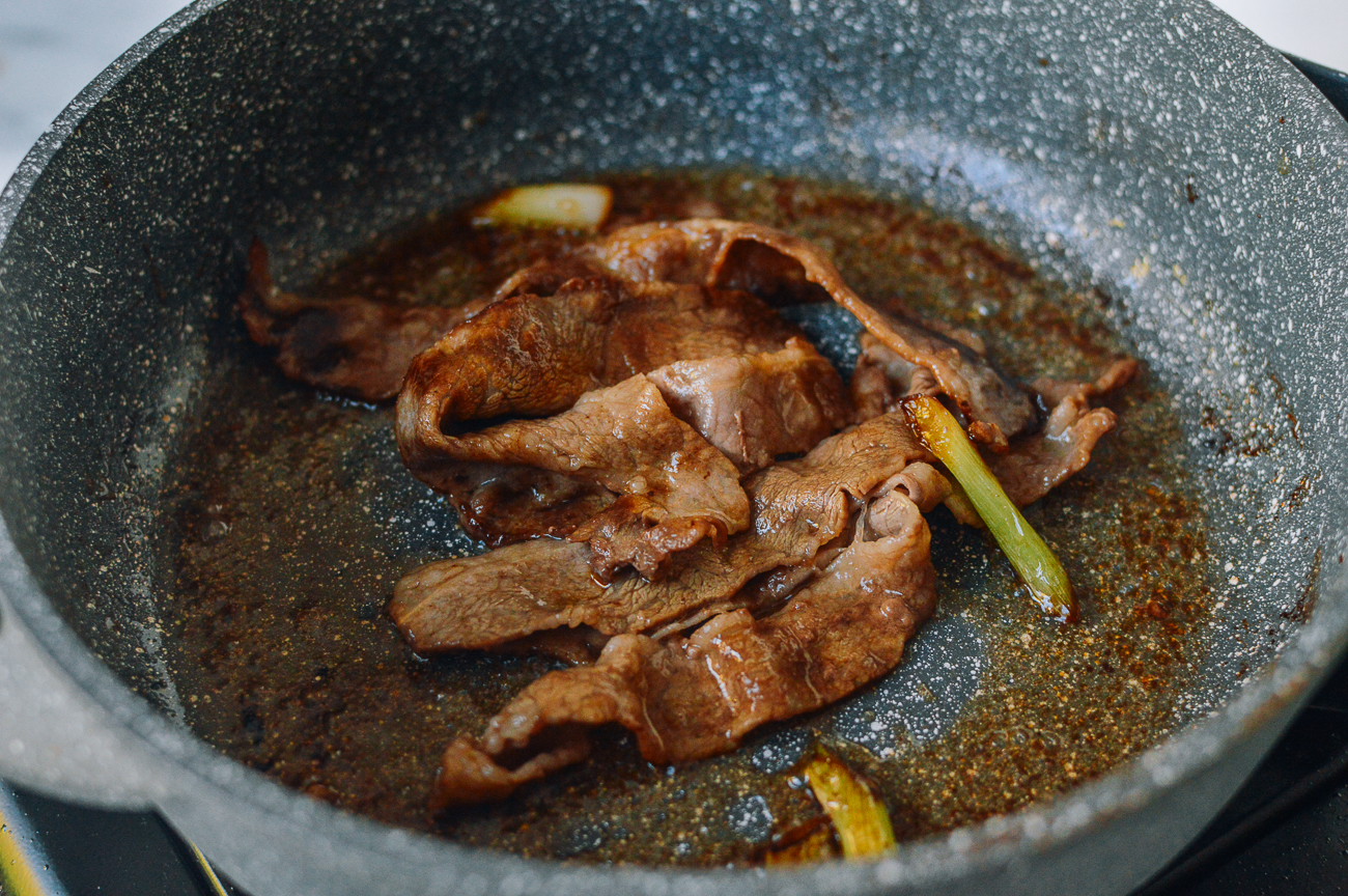 cooked thinly sliced beef in pan