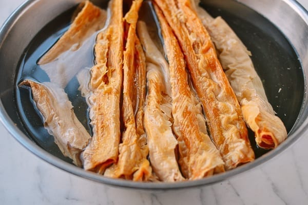 dried bean curd sticks soaking in bowl of water