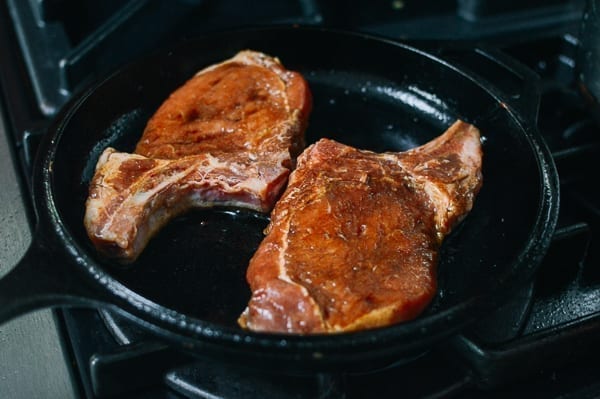 Asian Pork Chops cooked in a cast iron pan, by thewoksoflife.com