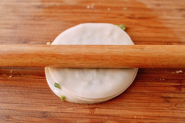 Rolling out scallion pancake made with layered dumpling wrappers, thewoksoflife.com