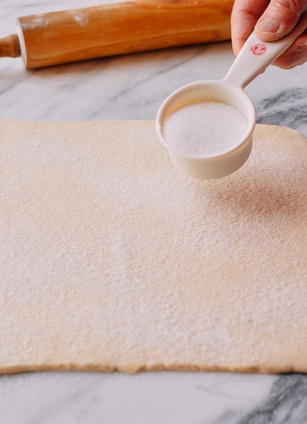 Spreading sugar on top of puff pastry dough, thewoksoflife.com