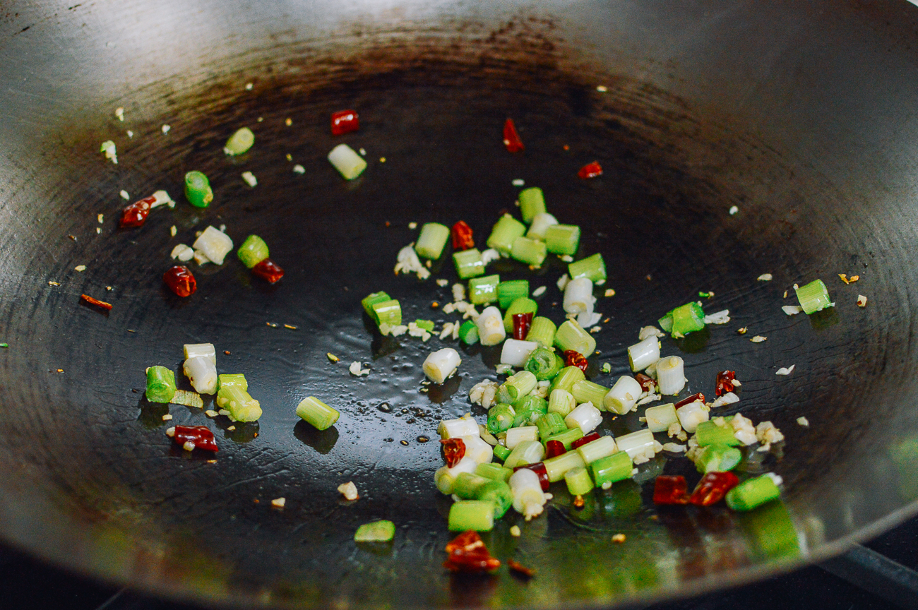 cooking aromatics in wok for kung pao chicken