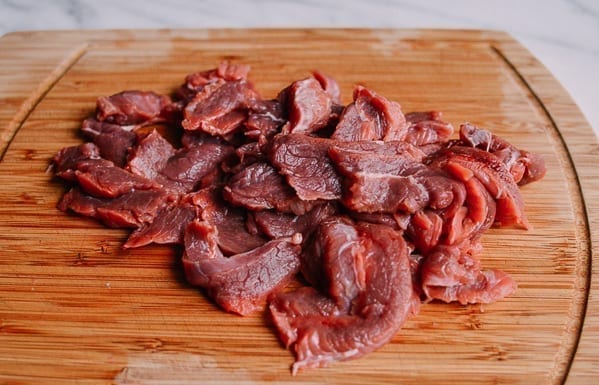beef flank steak slices on cutting board by thewoksoflife.com