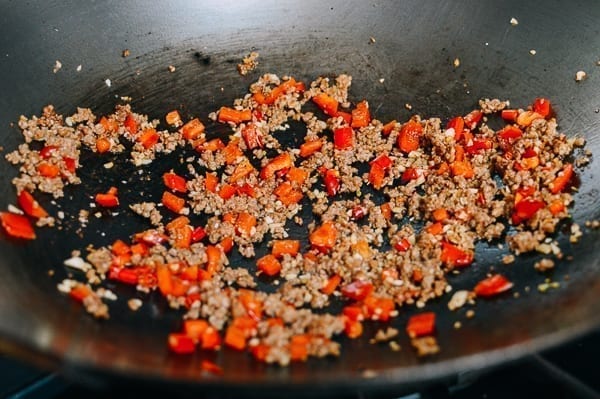 Stir-frying pork, bell pepper, chilies, and garlic, thewoksoflife.com