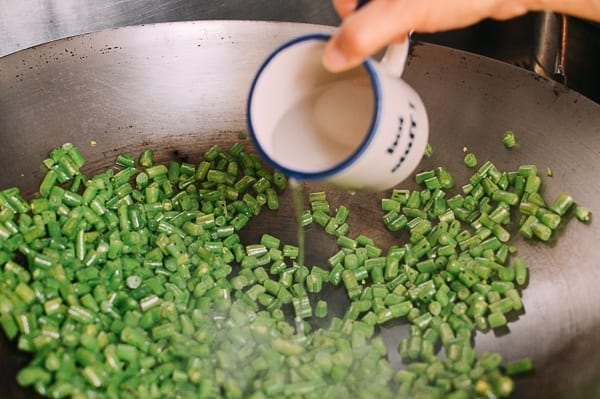 Adding water to wok seared green beans, thewoksoflife.com