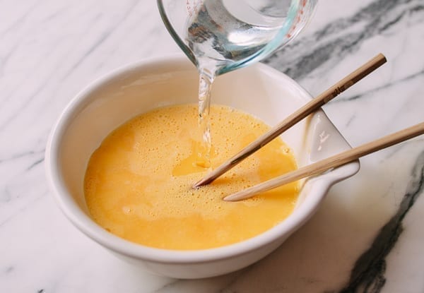 Adding water to steamed egg mixture, thewoksoflife.com