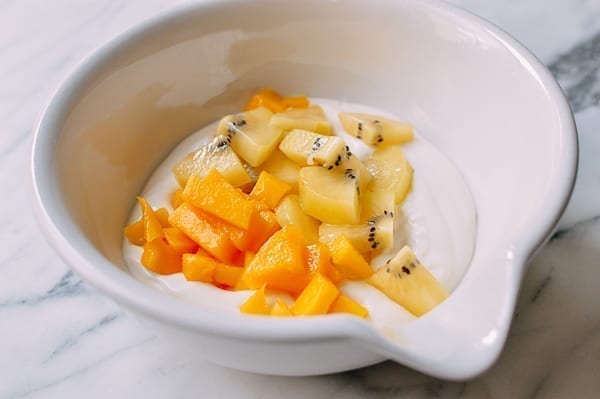Folding mango and kiwi into yogurt, thewoksoflife.com