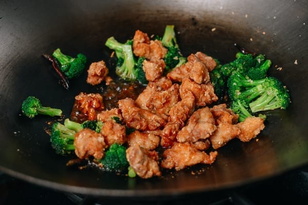 Tossing chicken and broccoli in sauce, thewoksoflife.com