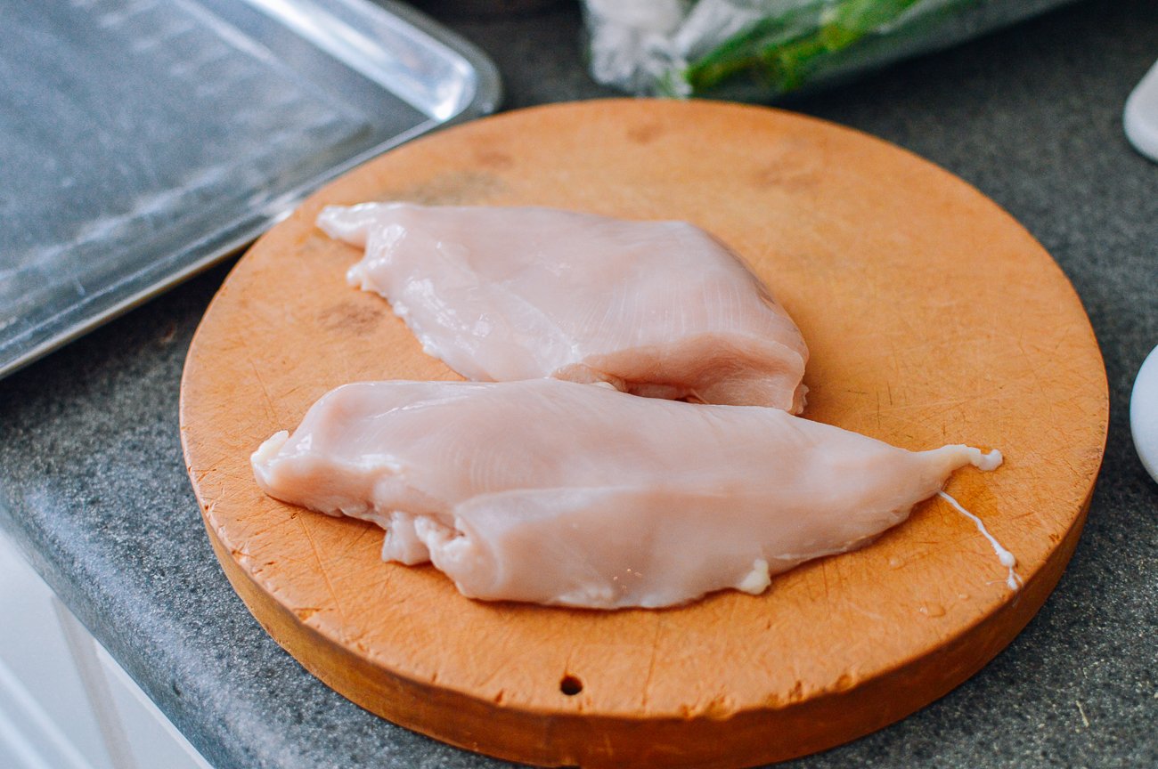 two boneless skinless chicken breasts on cutting board