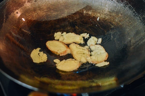 Smashed ginger slices in oil in wok, thewoksoflife.com