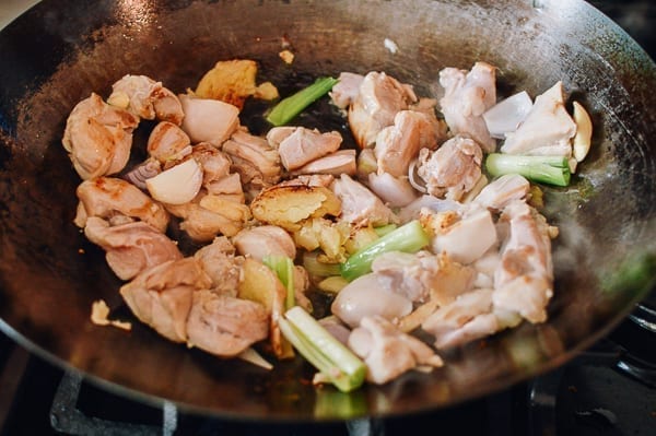 Adding scallions and garlic to chicken stir-fry, thewoksoflife.com