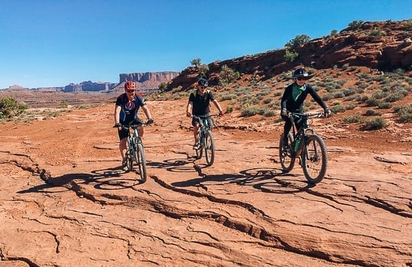 three Mountain bikers on White Rim Trail Moab Utah by thewoksoflife.com