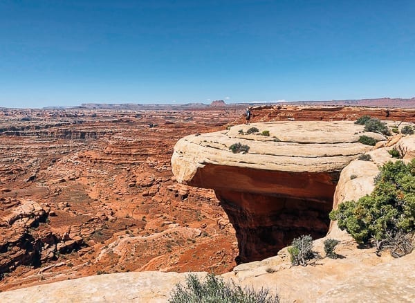 scenic view of hiker near white crack on White rim trail in Canyonlands by thewoksoflife.com