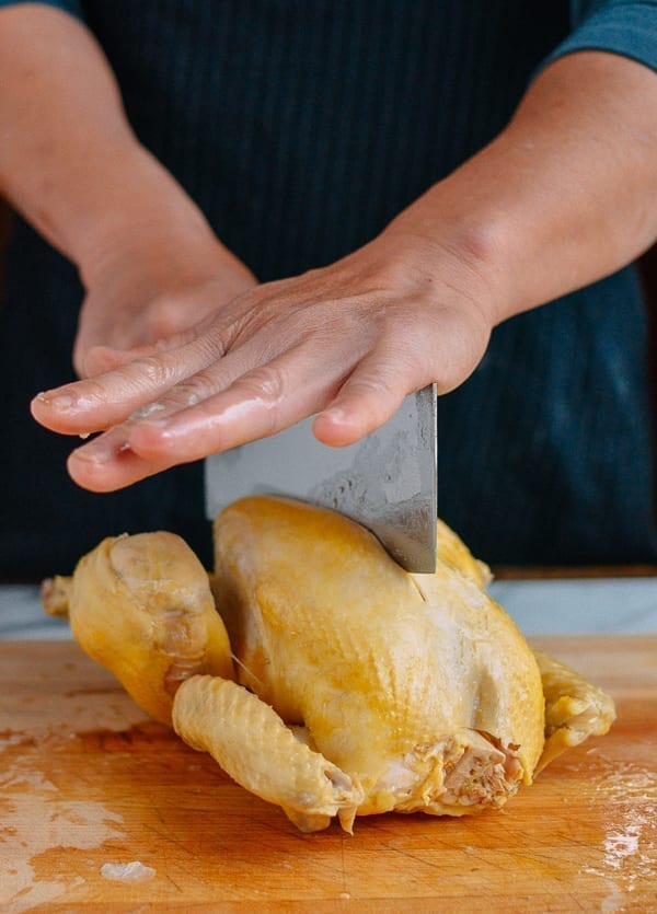 Pushing knife through whole chicken, thewoksoflife.com