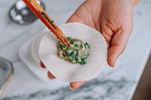 Adding a tablespoon of filling to dumpling wrapper, thewoksoflife.com