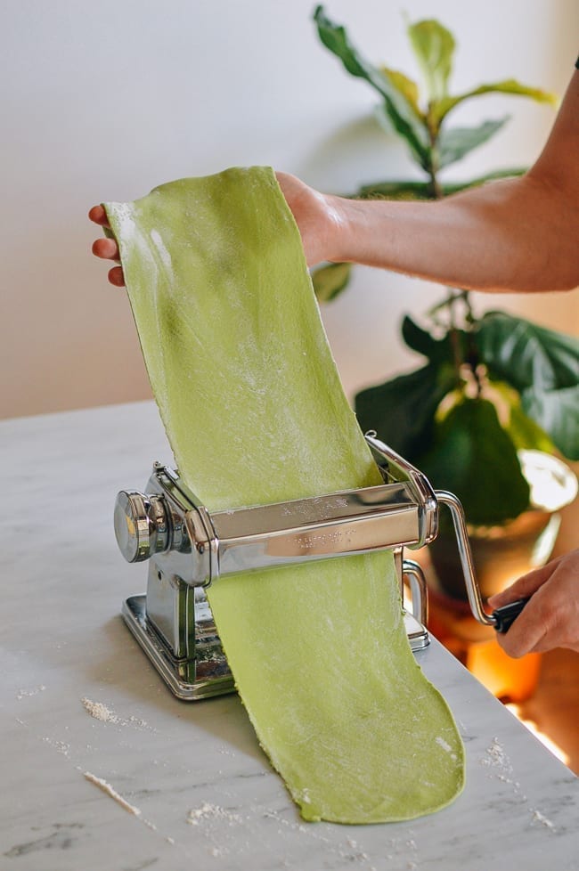 Rolling spinach pasta dough through pasta roller, thewoksoflife.com