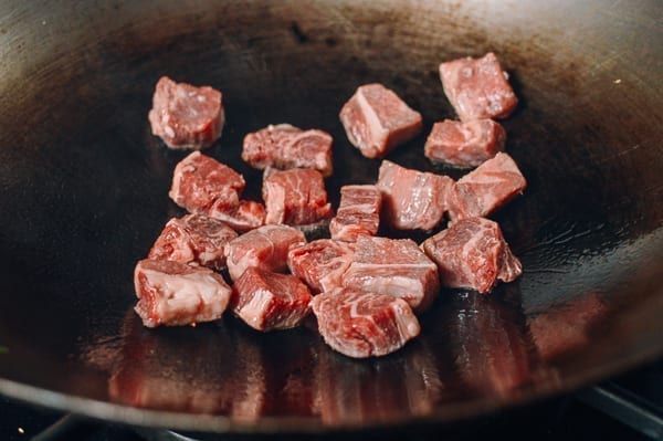 Searing steak cubes in wok, thewoksoflife.com