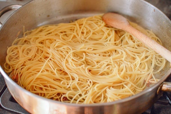 Adding cooked spaghetti to pan, thewoksoflife.com