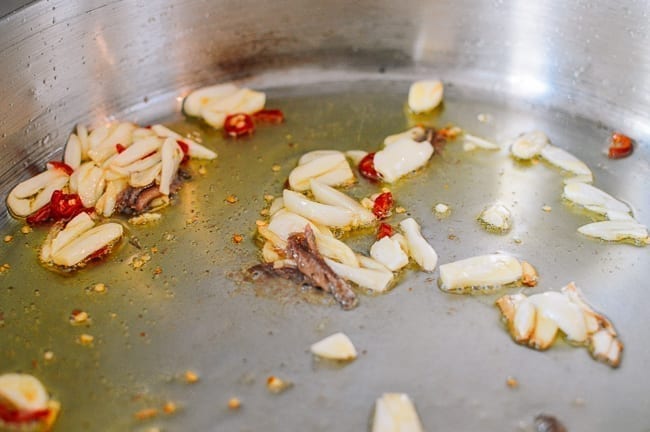 garlic, chili, and anchovy cooking in oil, thewoksoflife.com