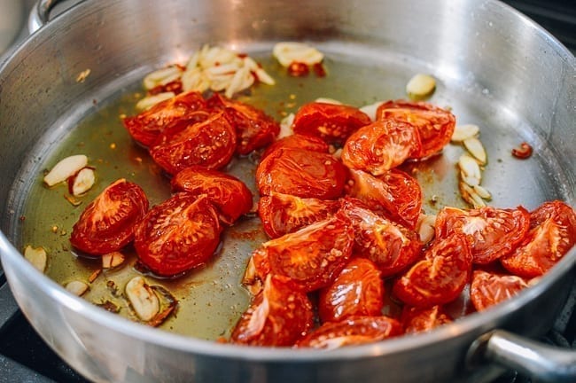Adding tomatoes and tomato paste, thewoksoflife.com