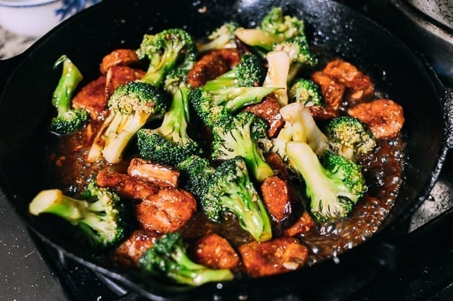 Tossing broccoli and nuggets in sauce, thewoksoflife.com