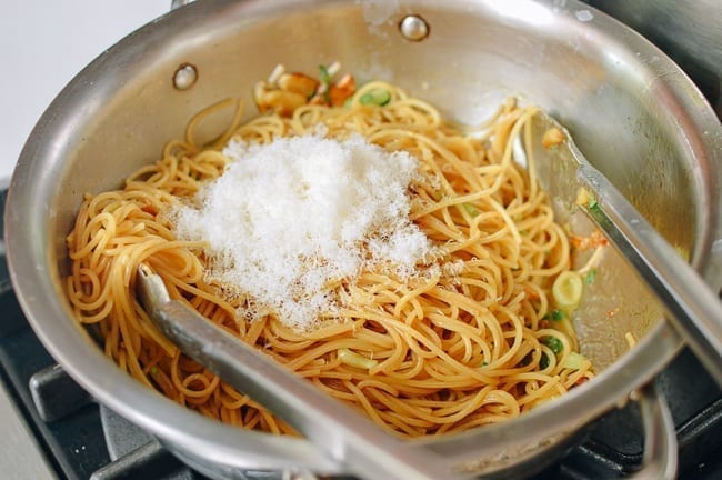 Adding cooked pasta and parmesan cheese to sauce, thewoksoflife.com