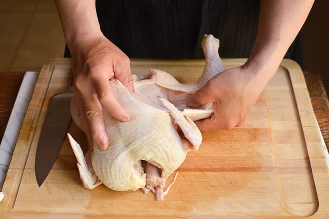 Pulling chicken leg quarter away from chicken